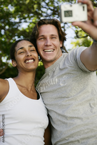 Photo: Couple taking self portrait with digital camera Couple taking self portrait with digital camera