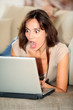 Woman with surprised look in front of computer