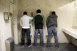 three men stading up, peeing in the bathroom
