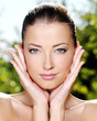 Woman stroking her fresh clean skin of face Woman stroking her fresh clean skin of face