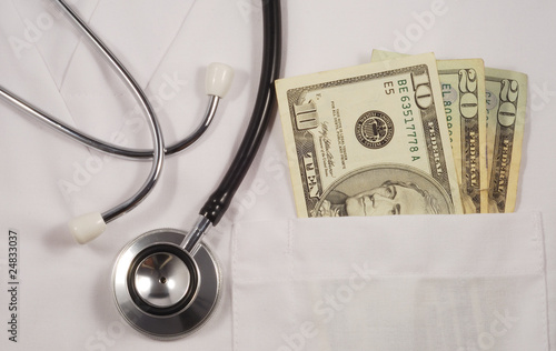 Photo: Money in doctor’s pocket concepts of rising medical cost Money in doctor’s pocket concepts of rising medical cost
