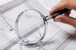 woman’s hand holding a magnifying glass woman’s hand holding a magnifying glass