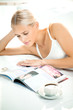 Young woman reading a magazine at bedroom