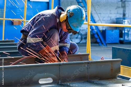 Photo: worker weld metal in factory and sparks worker weld metal in factory and sparks