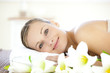 Charming woman lying on a massage table looking at the camera Charming woman lying on a massage table looking at the camera