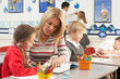 Group Of Primary Schoolchildren And Teacher Having lesson In Cla
