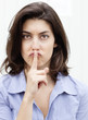 jeune femme index sur la bouche signe de silence