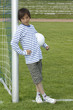 Foto: Junge mit Fussball, freundlich, am Tor angelehnt Junge mit Fussball, freundlich, am Tor angelehnt