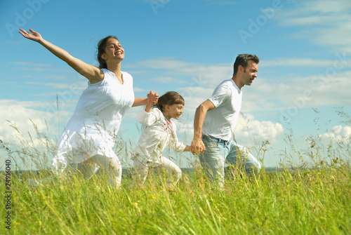 Foto: Happy family run on meadow Happy family run on meadow