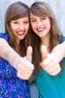 Young women giving thumbs up