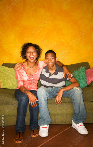 Photo: African-American woman and teen on green sofa African-American woman and teen on green sofa