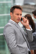 Businessman standing in front of offices outside Businessman standing in front of offices outside