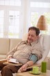 Old man measuring blood pressure at home