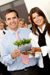 Business couple holding a plant