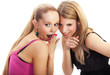 Two young woman whispering secrets
