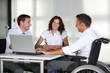Foto: Businessman in wheelchair working in the office with colleagues Businessman in wheelchair working in the office with colleagues