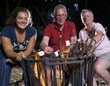 Family at campfire in the garden with marshmallows
