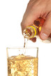 man's hand pours a drink into a glass