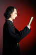Photo: conceptual portrait of Praying priest with wooden cross reading conceptual portrait of Praying priest with wooden cross reading