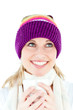Merry young woman holding a cup wearing a cap in the winter Merry young woman holding a cup wearing a cap in the winter