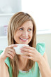 Charming caucasian woman holding a cup of coffee sitting in the Charming caucasian woman holding a cup of coffee sitting in the