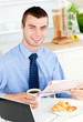 Handsome businessman reading the newspaper drinking coffee