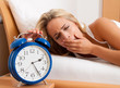 Photo: Schlaflos mit Uhr in der Nacht. Frau kann nicht schlafen. Schlaflos mit Uhr in der Nacht. Frau kann nicht schlafen.