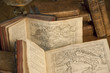 Vintage books and old maps on a wooden table.
