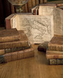 Vintage books and old maps on a wooden table.