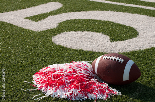 Photo: American Football and Pom Poms on Field American Football and Pom Poms on Field