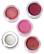 Multy-colored lip gloss in round silver plastic containers on wh Multy-colored lip gloss in round silver plastic containers on wh