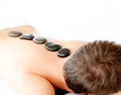 Young caucasian relaxing man with hot stone on his back Young caucasian relaxing man with hot stone on his back