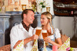 Paar in Tracht trinkt Weißbier