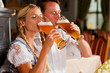 Paar in Tracht trinkt Weißbier