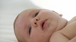 close-up of a baby lying on a bed