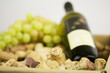 Weinkorken in Kiste mit Wein und Trauben