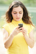Young woman reading message on cellphone