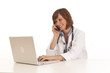 Portrait of young woman doctor at computer using phone Portrait of young woman doctor at computer using phone