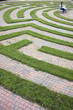 Woman Using Laptop in a Cobblestone Maze