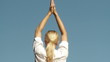 woman from back doing yoga outside
