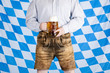 Bayerischer Mann in Lederhose hält Oktoberfest Maß Bier