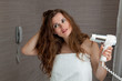 dressed in towel beautiful woman using fen at modern bathroom