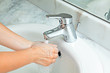 woman washing hands at modern marble bathroom. bubbled water