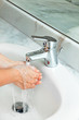 woman washing hands at modern marble bathroom. bubbled water