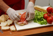 Manos preparando sandwitch.