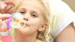 cute daughter doing soap bubbles with her mother