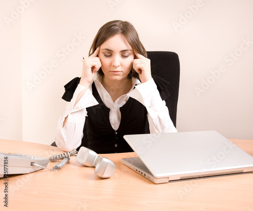 Photo: Young businesswoman massaging temples Young businesswoman massaging temples