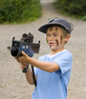 A young boy with camouflage paint on his face preparing to play
