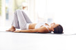 Exercising - Young fitness woman lying on a yoga mat