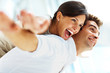 Happy female enjoying a piggyback ride on boyfriends back